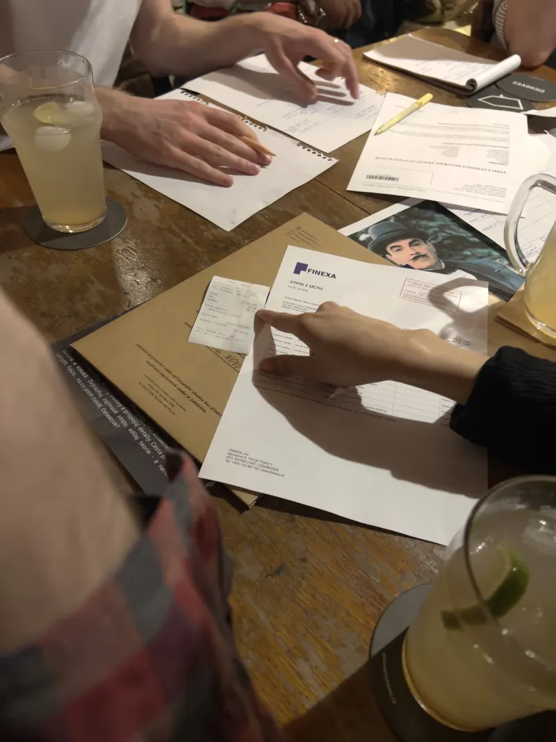 Detail stolu s herními materiály na detektivním Friendzy večeru